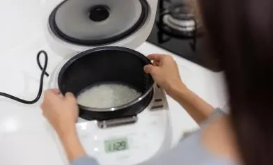 imagem de uma panela elétrica de arroz sobre a pia